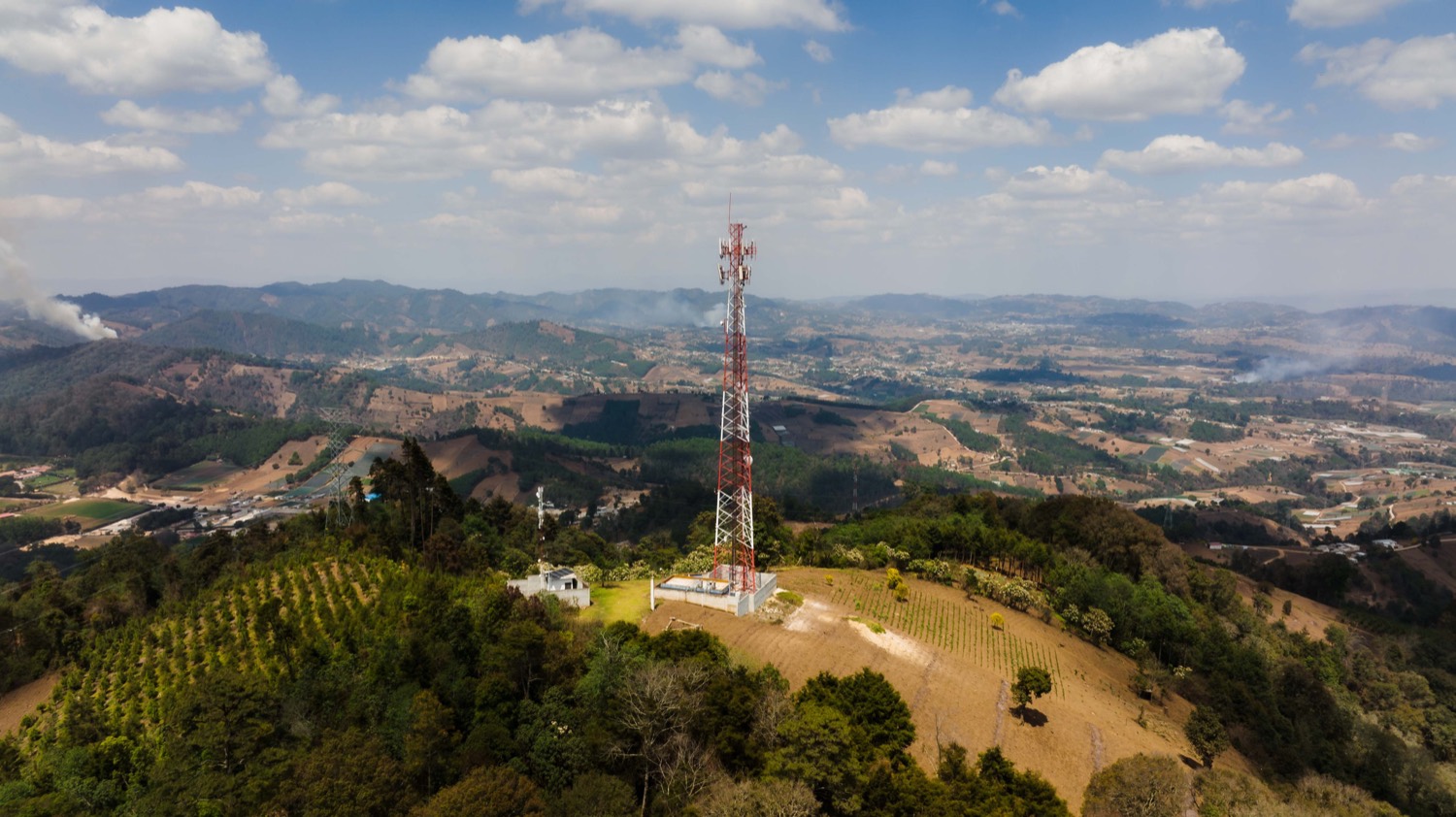 Aerial view of a Spearnet telecommunications tower on a green hilltop in rural South Africa